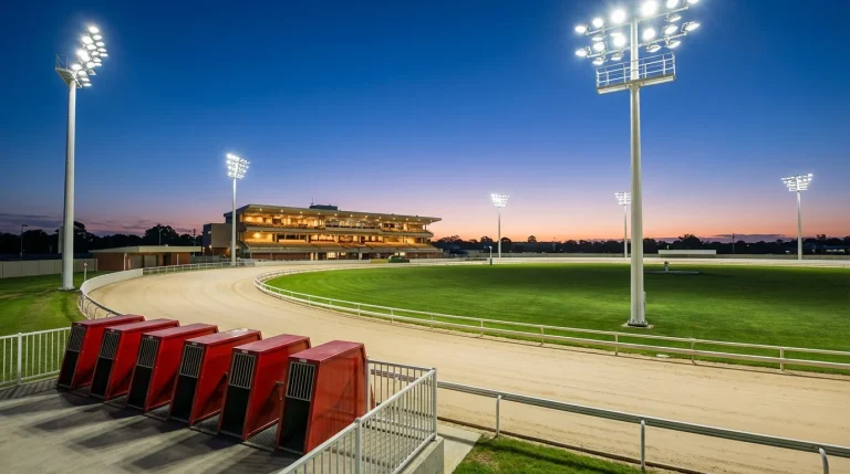 Sand oval greyhound racing track with starting traps and floodlights at a UK venue